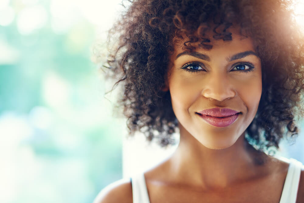 smiling young black woman with sunlight flare