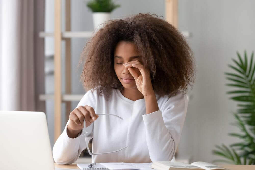 Woman rubbing her eye in pain